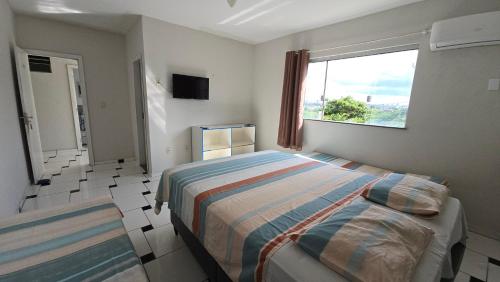 a bedroom with a bed and a window in it at Hotel Pousada Positiva in Itabuna