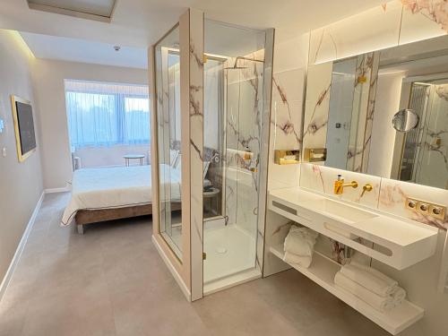 a bathroom with a shower and a bed in a room at Belenus Thermalhotel in Zalakaros