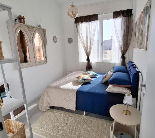 a bedroom with a blue bed and a window at BlueCharme modern apartment in Quartu SantʼElena