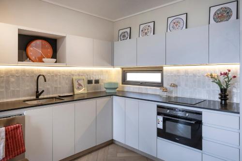 a kitchen with white cabinets and a sink at Pueblo La Dehesa in Santiago