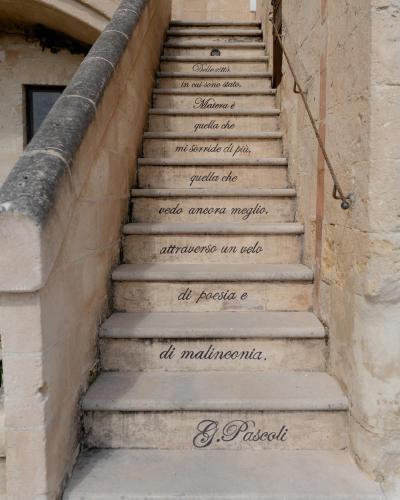 a staircase with writing on the side of a building at Palazzo Del Duca Hotel & Restaurant in Matera