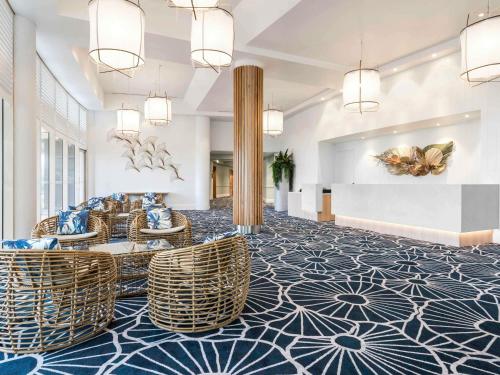 a lobby with wicker chairs on a blue and white floor at Mantra Twin Towns in Tweed Heads
