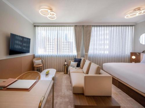 a hotel room with a large bed and a couch at Mantra Terrace Brisbane in Brisbane