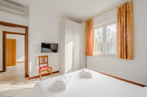 a room with a bed and a chair and a window at Hotel Nuova Barcaccia in Peschiera del Garda