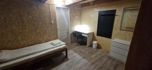 a small room with a bed and a desk at Attic rooms-Bēniņu istabas in Jelgava