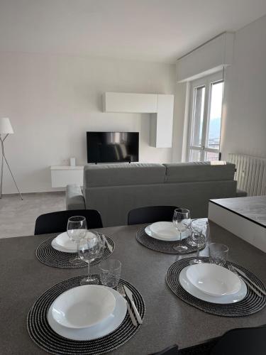 a dining table with plates and wine glasses on it at Lake at Home in Lecco