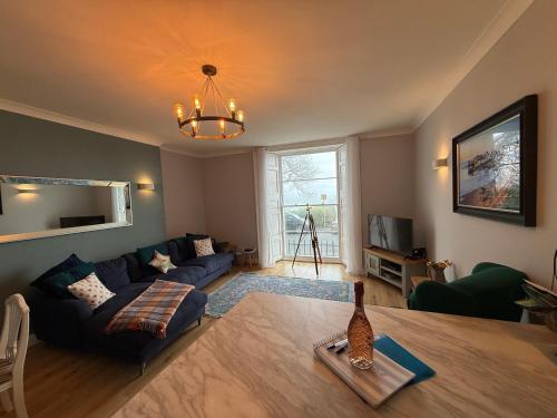 a living room with a couch and a table at Newton Croft Tenby overlooking North Beach in Tenby