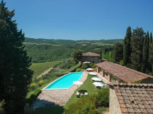 an overhead view of a swimming pool with umbrellas and a house at Santo Pietro Resort in San Gimignano