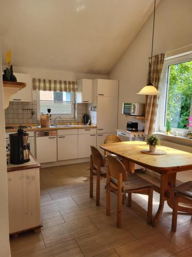 a kitchen with a wooden table and chairs and a table and a dining room at Haus Teelke in Papenburg