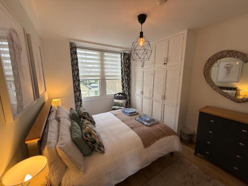 a bedroom with a bed and a large window at Newton Croft Tenby overlooking North Beach in Tenby