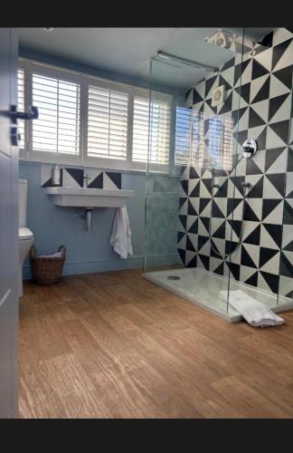 a bathroom with a glass shower and a sink at Hues - Castle Cary in Castle Cary