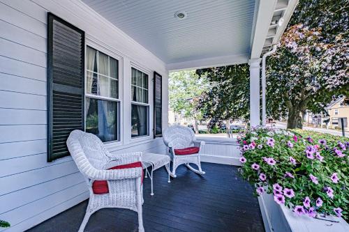 two chairs and a table on a porch with flowers at The Nicholson Inn in Freeport