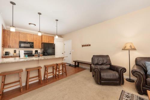 a living room with a couch and chairs and a kitchen at Ten Mile G201 in Granby