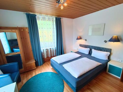 a bedroom with a blue bed and a blue chair at Hotel Pfaff in Triberg