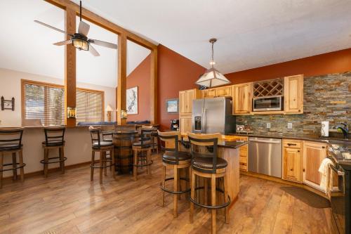 a large kitchen with wooden cabinets and bar stools at Mountainside Unit B-20 in Granby