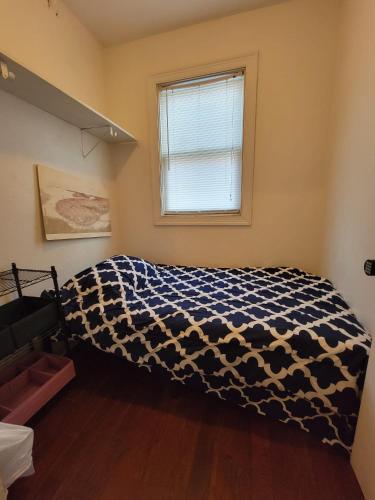 a bedroom with a bed with a black and white blanket at Esjacpe Guest House 2 in Boston