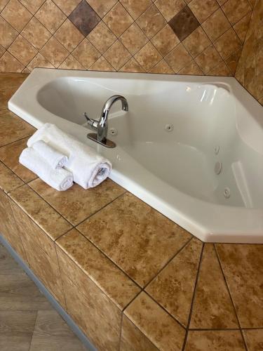 a white bath tub with two towels sitting in it at Comfort Inn & Suites Dayton Northwest - Englewood in Dayton
