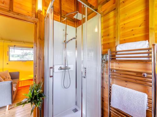 a bathroom with a shower in a tiny house at Little North Field Family Safari Tent Glamping near Harrogate in Harrogate