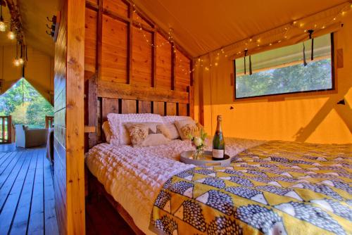 a bedroom with a bed and a bottle of wine at Little North Field Family Safari Tent Glamping near Harrogate in Harrogate