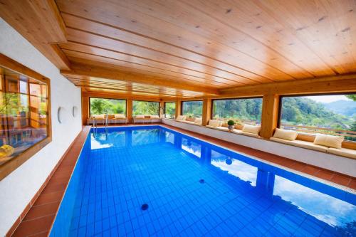 a large swimming pool with a wooden ceiling at Landhaus Langeck in Münstertal