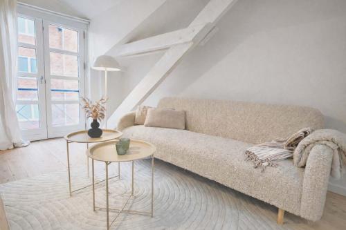 a living room with a couch and two tables at Cozy Oasis perfect for couples & solo travelers in Viborg