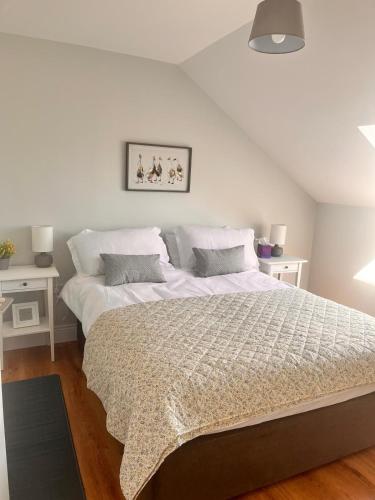 a bedroom with a large bed with white sheets at Drumquin Accommodation in Ennis