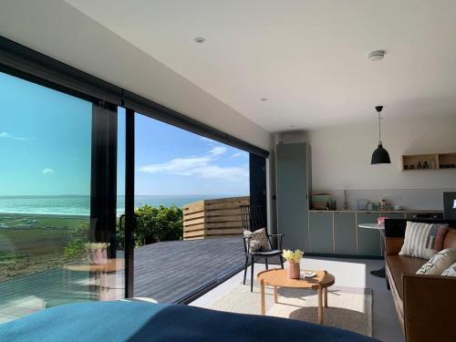 a bedroom with a view of the ocean from a house at Subterranean Studio with Panoramic Costal Views and Sauna in Pembrokeshire