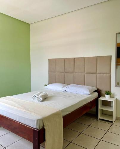 a bedroom with a large bed with a headboard at Alameda Hotel Centro in Garanhuns