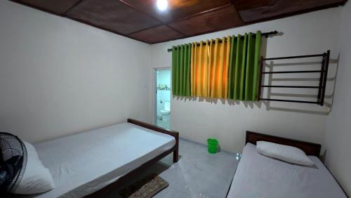 a small room with a bed and a curtain at Diws Holiday Bungalow in Anuradhapura