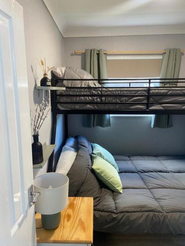 a bedroom with a bunk bed and a table at 106 Cherry park in Chapel Saint Leonards
