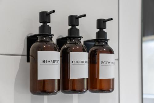 a group of four bottles of soap on a shelf at Lesmahagow Hilltop View in Lesmahagow