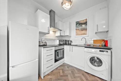 a white kitchen with a washer and dryer at Lesmahagow Hilltop View in Lesmahagow