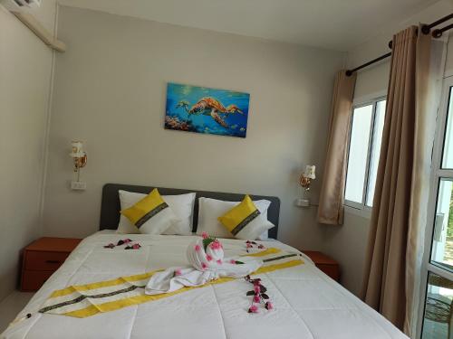 a bedroom with a white bed with flowers on it at Mumzai House in Ko Mook