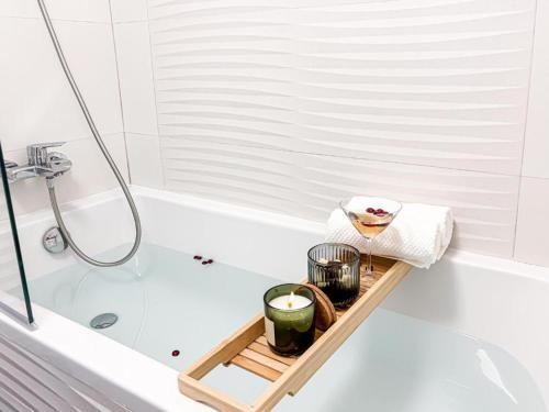 a bathroom with a tray with candles and a bath tub at Cloud 9 Bucharest Residence in Bucharest