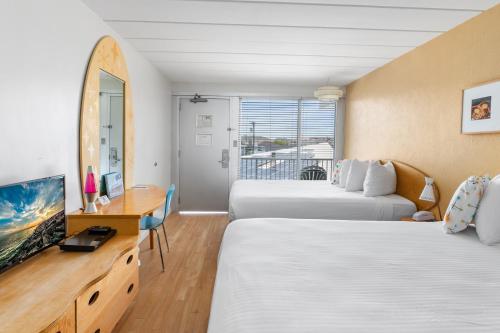 a hotel room with two beds and a television at The StarLux in Wildwood