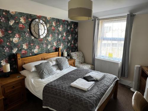 a bedroom with a bed with a floral wallpaper at Willows Guest House in Great Yarmouth