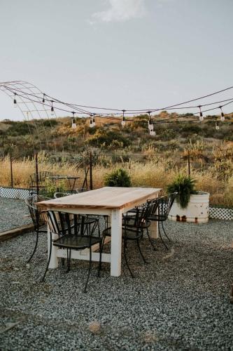 a table and chairs sitting around a table with a field at Quiet Luxury Tiny Home Retreat Rustic Chic in Aguanga