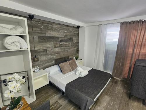 a bedroom with a bed and a wooden wall at Alojamientos Santa Pola in Santa Pola