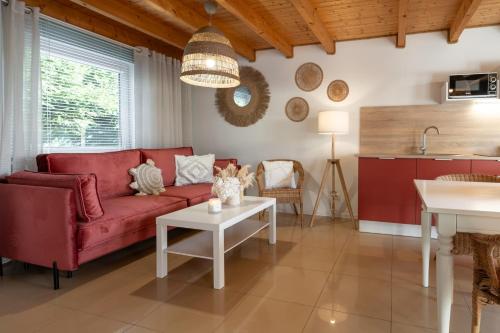 a living room with a red couch and a table at DOMKI LAURA sauna & gorąca balia in Jastrzębia Góra