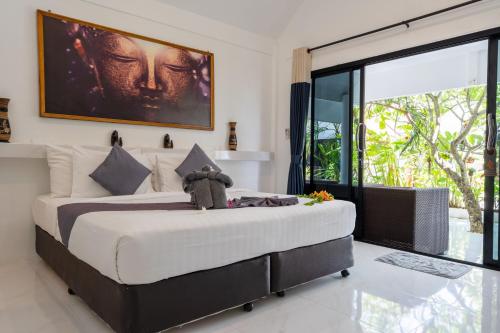 a bedroom with a large bed with a teddy bear on it at Bungalow - Sleeps 2 - Terrace - Beach Close in Ko Lanta