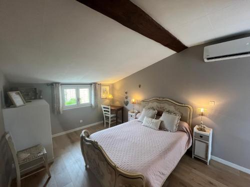 a bedroom with a bed with white sheets and pillows at Chambres et Gîte PEYROUTAS " CAMILLE" Vignonet St Emilion in Vignonet