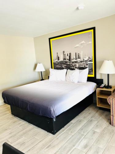 a bedroom with a large bed with a picture on the wall at Super 8 by Wyndham Corpus Christi in Corpus Christi