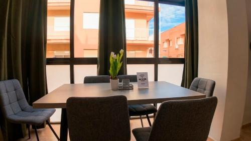 a table and chairs in a room with a large window at Apartalux San Pedro Playa in San Pedro del Pinatar
