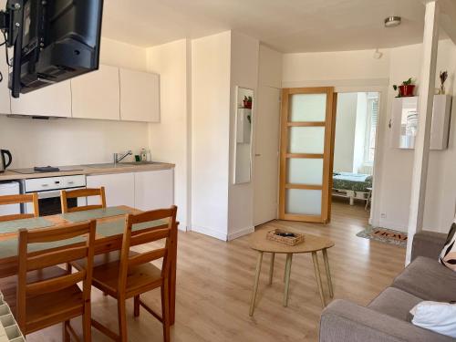 una cucina e un soggiorno con un tavolo e un divano di Le Petit Milly a Milly-la-Forêt