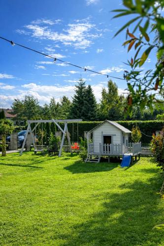 a yard with a swing set and a playground at DOMKI LAURA sauna & gorąca balia in Jastrzębia Góra