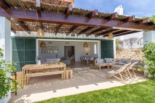 a patio with a couch and a table and chairs at Villa Conguitosby 3VILLAS in Sant Lluis