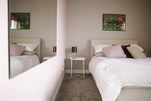 a bedroom with two beds and a table with a lamp at Central Dundee, 1 Bed, Parking, 3 Nights in Dundee