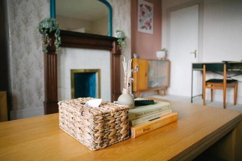 a table with books and a vase on top at Central Dundee, 1 Bed, Parking, 3 Nights in Dundee