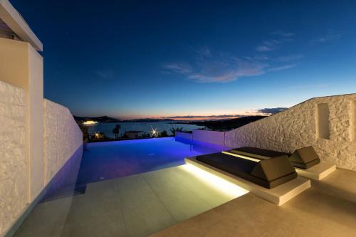 a villa with a swimming pool at night at Paros Agnanti Resort & Spa in Parikia