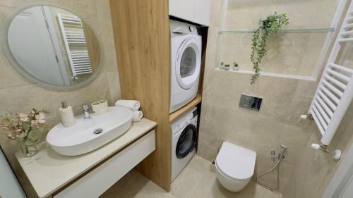 a bathroom with a sink and a washing machine at Parkside Dighomi in Tbilisi City